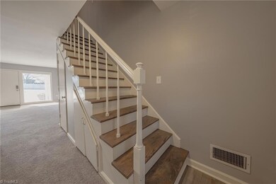 Looking into the living room and the stairs lead to 2 bedrooms and full bath.