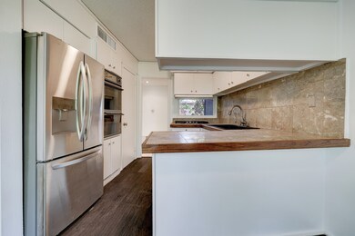 Kitchen with tile countertops, double ovens, and s