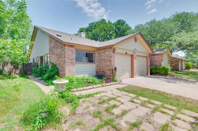 View of front facade with brick siding, driveway,