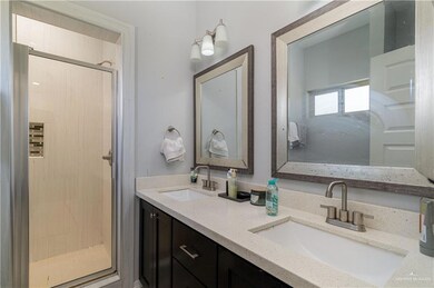 Bathroom featuring double vanity, a sink, and a shower stall