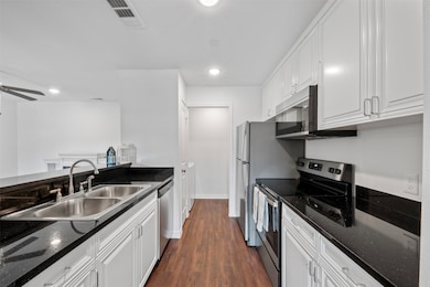 The kitchen features sleek stainless steel applian