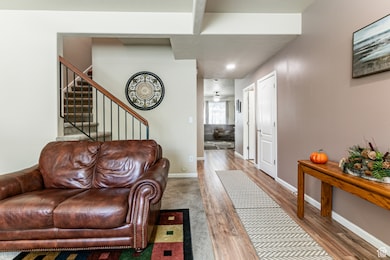 Living area with wood finished floors, stairs, and recessed lighting
