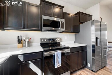 Kitchen with dark brown cabinets, stainless steel 