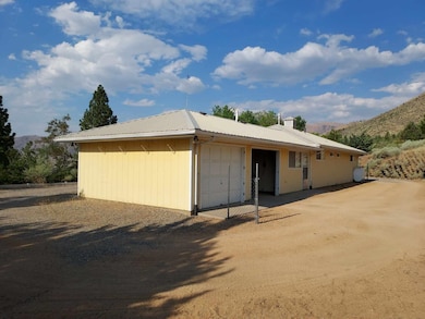 View of front of home featuring a mountain view, a garage, a metal roof, and a chimney