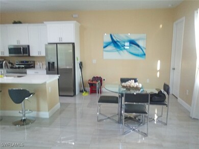 Kitchen featuring a breakfast bar, a sink, light c