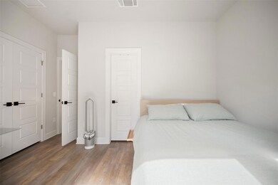 Bedroom featuring wood finished floors and basebo