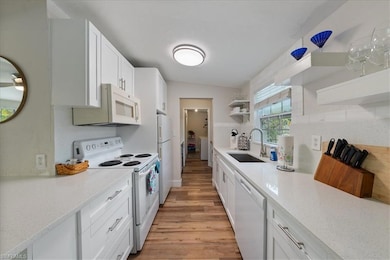 Kitchen featuring white cabinets, open shelves, a 