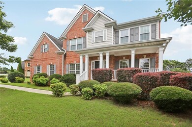 View of front of house featuring brick siding, a front lawn, and covered porch