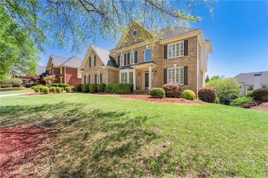 Colonial home with brick siding and a front lawn