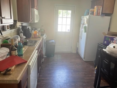 Kitchen featuring white appliances and dark wood-style flooring