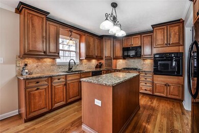 Luxurious remodeled kitchen features granite counter tops, tile backsplash, large island and pantry.