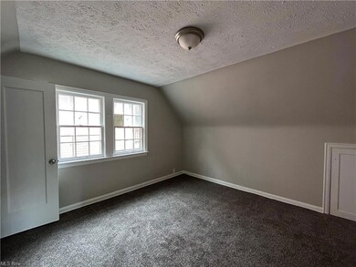 Bonus room with dark carpet, lofted ceiling, and a