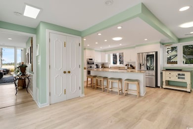 Kitchen with white cabinetry, light wood-style flo