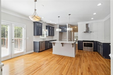 Kitchen with light wood-style floors, wall chimney