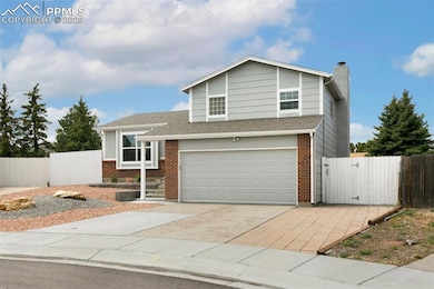 View of front of home with fence, a garage, brick 