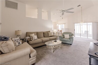 Carpeted living room featuring ceiling fan with no