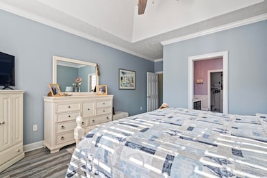 Bedroom featuring crown molding, dark wood-type fl