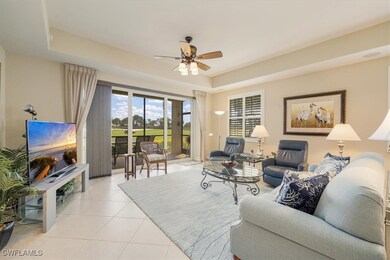 Living room featuring a tray ceiling, ceiling fan,