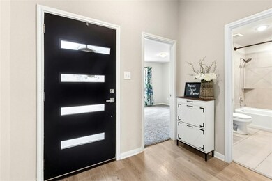 Foyer with light wood-type flooring and baseboards