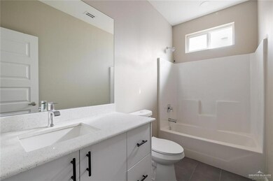 Full bathroom with toilet, tub / shower combination, tile patterned floors, visible vents, and vanity