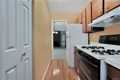 Galley style kitchen with hardwood.  Appliances co