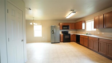 Kitchen with black appliances, a sink, a chandeli