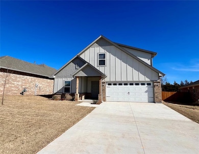 View of front facade with driveway, board and batten siding, and brick siding