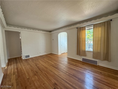 Great room with a textured ceiling and hardwood / wood-style floors