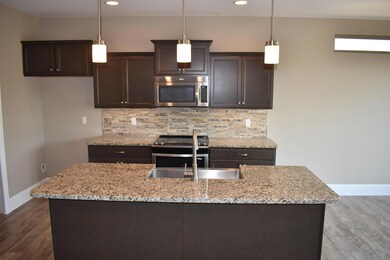 island K w/ granite and tile backsplash