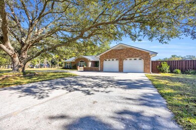 Single story home with a garage and a front lawn