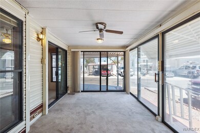 Unfurnished sunroom featuring ceiling fan