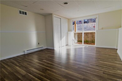 In the far back corner is a large room with sliding doors and new laminate flooring