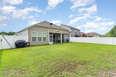 Rear view of house with a lawn and a sunroom