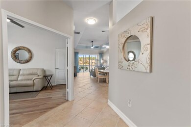 Hall featuring a raised ceiling and light tile pat