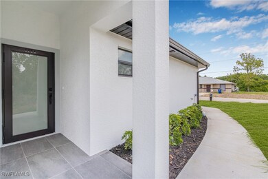 Property entrance with stucco siding and a yard