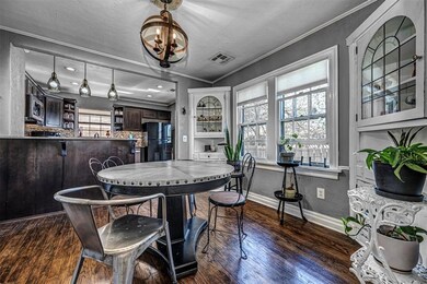 A globe chandelier hangs over a charming dining space and it's corner cabinets.