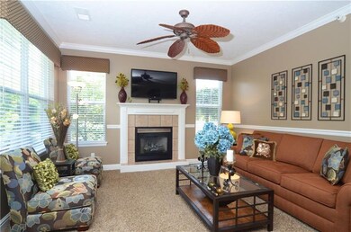 Living room with gas fireplace and ceiling fan.  L