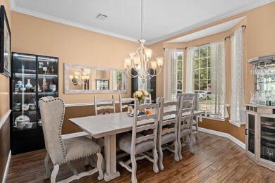 The dining room features warm walls, elegant crown