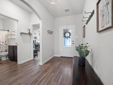 Foyer featuring arched walkways and wood finished