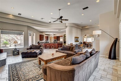 Living room featuring a ceiling fan, stone tile fl