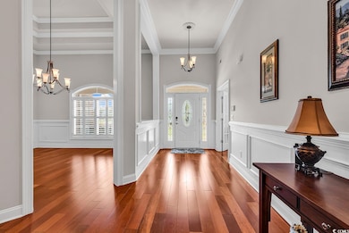 Foyer entrance with an inviting chandelier, wood f