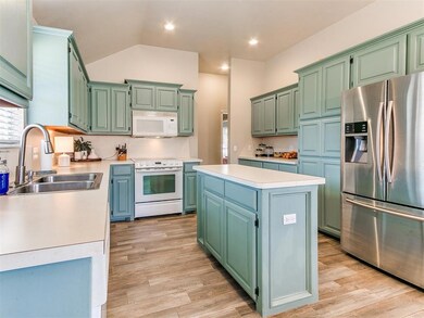 Kitchen with light wood-type flooring, white appli