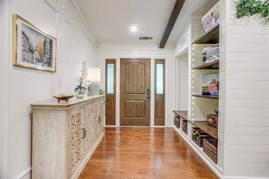 Foyer featuring beam ceiling, crown molding, and l