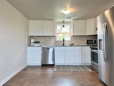 Kitchen with light stone countertops, sink, white 