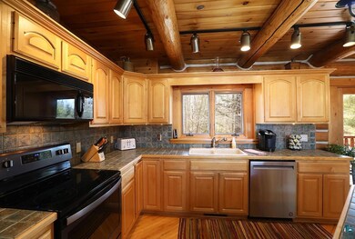 Kitchen featuring black appliances, a sink, track 