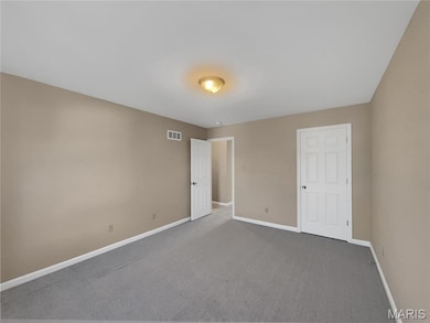 Unfurnished bedroom with carpet flooring and baseboards