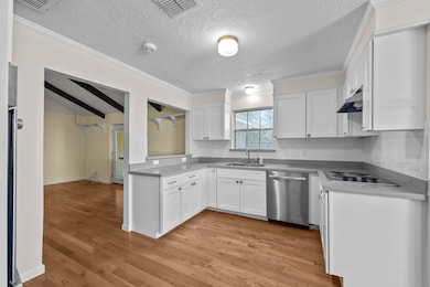 Updated kitchen with shaker cabinets, solid surface counters and stainless appliances
