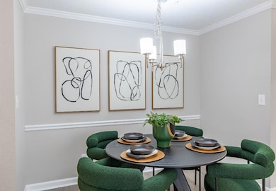 Dining area with an inviting chandelier, crown mol