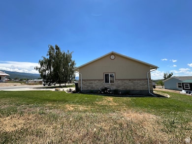 North Side View of property exterior with brick siding, a yard, and a mountain view