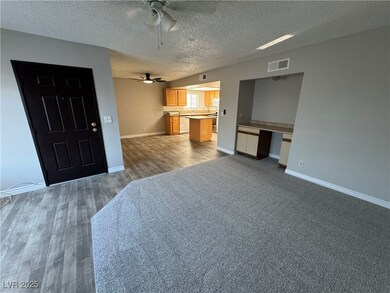 Unfurnished living room featuring a textured ceiling and dark wood-style floors